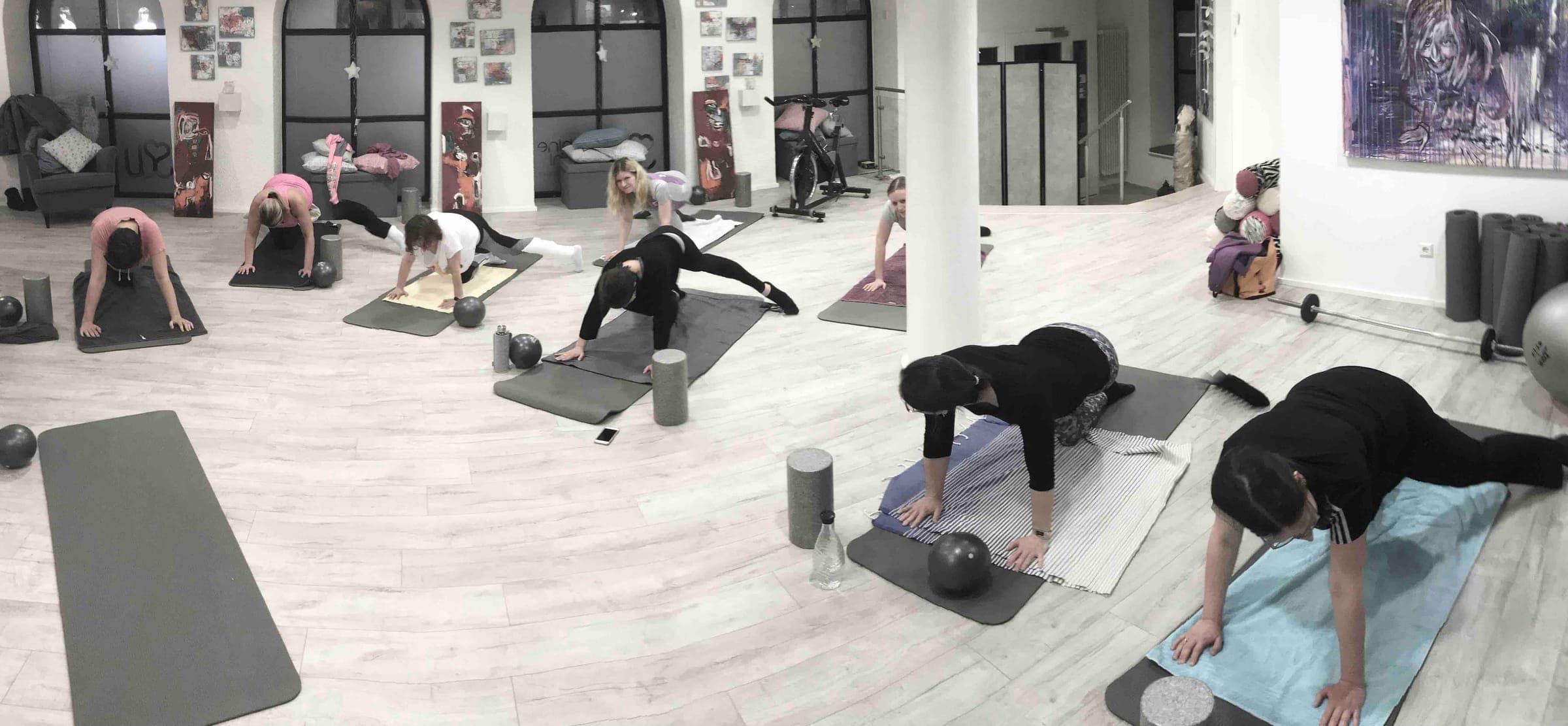 Gruppe beim Firmensport im Studio, Übungen auf Matten